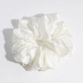 Detailed view of a white satin scrunchie showing glossy silk texture and rich folds - White Small