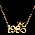 Golden 1985 year number pendant necklace with crown detail on black background - 1985 / Gold