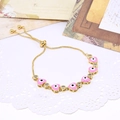 Detailed close-up of pink heart-shaped evil eye bracelet with sparkling cubic zirconia charms - Pink