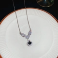 Macro shot of Y-shaped silver necklace with square clear crystals and black gemstone detail - Necklace-Silver-Black
