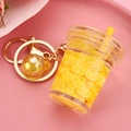 Detail of creative lemon tea keychain with floating lemon slices and gold lobster clasp - Yellow Cup