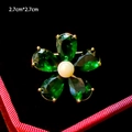Macro shot of a floral brooch with green petals and a white pearl on black velvet - Green Petal Pearl Floral Style (B895)