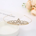 Detailed close-up of golden bridal crown with sparkling rhinestones on white ceramic - Crown Style 16