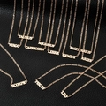 Detailed flat lay of 18K gold-plated zodiac name necklaces on black leather background - Rose Gold 12PCS Set
