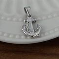 Pendentif ancre en acier inoxydable argenté poli sur une assiette décorative blanche - Ancre / Acier