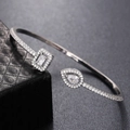 Detailed view of silver cuff bracelet with square and pear-shaped cubic zirconia stones - Silver White