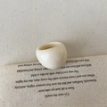 Minimalistischer cremefarbener Harzring mit klobigem Vintage-Design auf Retro-Stoffhintergrund - Ring / Creme