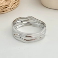 Macro-opname van een brede zilveren armband met gedeconstrueerde golfstructuur en grillige vorm - Onregelmatige Golf Scharnierende Armband (SL272) / Zilver