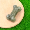 Deep greyish green carved natural stone bone miniature figurine on a wooden tray - Labradorite