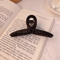 Large matte coffee brown hair claw clip for thick hair displayed on an open book - 11cm / Matte Black