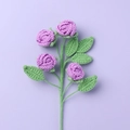 Detail of four purple crochet roses with green leaves on light background - Finished Bubble Rose (4 Heads Purple)