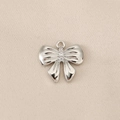 Detailed view of a silver bow pendant with three sparkling cubic zirconia accents - Vertical Three Stone Bow (PJ0161) / Silver