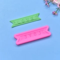 Pink silicone LOVE letter mold with green finished banner piece on blue background - Pink