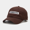 Detail of deep brown cotton baseball cap showing 1986 embroidery and stitch texture - Adjustable / Brown