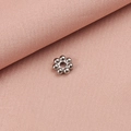 Detailaufnahme einer silbernen Schneeflocken-Abstandsperle für DIY-Schmuck auf Stoff - 4mm / Stahlfarbe