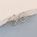 Detail of silver heart-shaped earring with organic curves on a textured stone surface - Silver Organic Stream Heart