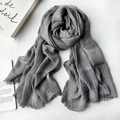 Neutral grey linen scarf with vertical stripes and frayed edges on a wooden table - 1477 Modal Gray