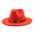 Detailed close-up of a red jazz fedora featuring a black leather band with silver metal studs - Orange Red