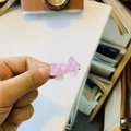 Dettaglio di un piccolo fermaglio rosa a forma di fiocco tenuto in mano sulla scrivania - Fermaglio a Becco d'Anatra con Fiocco Gingham Rosa