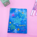 Detailed view of a blue plush Agenda notebook with sparkling sequin star on pink surface - Pentagram