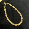 Close-up of golden money bag pendant bracelet with sparkling cubic zirconia on black velvet - Gold Braided Twist Style