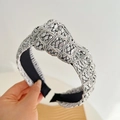 Close-up of a silver braided headband with intricate beaded texture held by hand - Silver Wide Knot Headband
