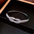 Detailsicht eines silbernen Knotenknoten-Armbands mit Strass in einer schwarzen Box - Silber