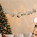 Silver Merry Christmas banner hanging in a warm festive living room with a Christmas tree - Silver Card / Silver