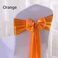 Elegant orange satin chair sash tied in a bow on white chair for wedding decor - Orange