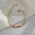 Detail of colorful faceted beads on a gold-plated link chain with lobster clasp - Multicolor Faceted Beads / Multi-color