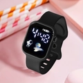 Gros plan d'une montre numérique carrée noire avec bracelet silicone et icône astronaute - Noir