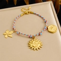 Adjustable woven bracelet in pink and blue with gold flower and sun disk pendants - Pink Blue Woven Smiley Sun Moon Flower Bracelet (B1726)