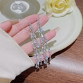 Silver long tassel earrings with sparkling crystals held over white rose background - E0057 Silver Needle (Dense Zircon Long Tassel Silver)