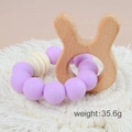 Baby teething bracelet with purple silicone beads and wooden rabbit ring on a woven mat - Rabbit/Purple Beads