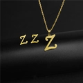 Macro detail of gold Z-letter pendant necklace and matching stud earrings on black background - Letter Z / Gold
