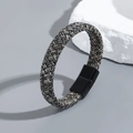 Détail macro du bracelet en cuir tressé multicouche avec fermoir magnétique en titane noir - Gris clair