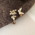 Detail of vintage flower tassel earrings with amber beads on brown knit fabric - Asymmetric Flower and Butterfly Style