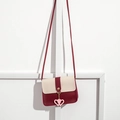 Detail of cream and burgundy crossbody bag featuring pink heart charms and slim strap - Burgundy