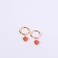Gold hoop earrings with pink heart crystal charms shown against a white background - July / Ruby