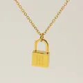 Minimalist golden necklace with a padlock pendant featuring Old English letter M engraving - Letter M Style