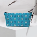 Waterproof Evil Eye makeup bag on white pedestal with dried lavender decoration - Blue All-Over Evil Eye