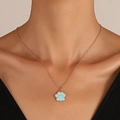 Nahaufnahme einer blauen Pfotenabdruck-Halskette an einer Goldkette mit schwarzem Top - Blau Emaille Katzenpfote / Gold/Blau