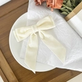 Elegant cream velvet bow hair clip with long ribbons on a decorative display - Beige