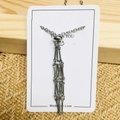 Gros plan d'un pendentif en métal argenté à franges sur carte avec design de bambou - 1 Pc Cage en Maille Argent