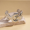Close-up of silver nautilus spiral cuff bracelet on stone base with textured details - Spiral Nautilus Texture Style