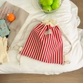 Detailed close-up of red and white striped knit drawstring backpack with logo label - Stripe Design / Red Stripes
