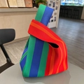 Rainbow striped knit knot bag with vibrant blue, green, orange and red vertical ribbing - Red Stripe