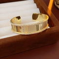 Detail van vergulde open armband met dubbele rijen kristallen in een fluwelen doosje - Goud
