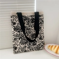 Detail of black and white paisley knit tote bag with black strap and silver snap button - Black White Paisley