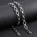 Detalle de collar geométrico plateado con patrón griego sobre superficie negra - Pulsera 19CM / Color Acero